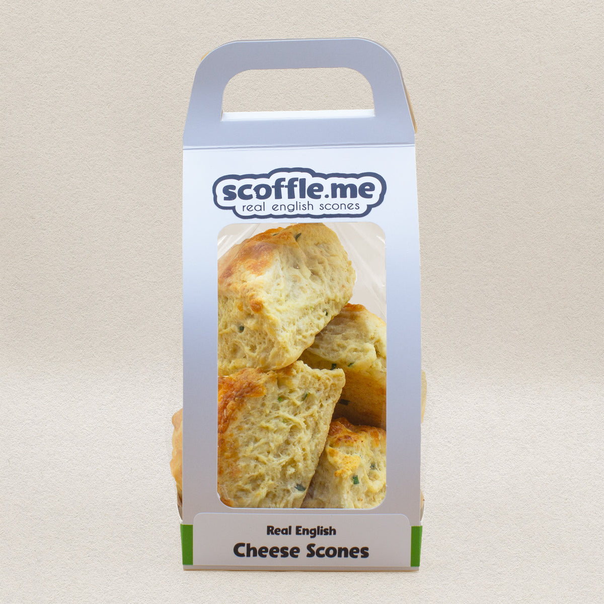 A cute white handled bag showcasing four delicious and rustic looking savory scones baked with cheddar cheese and chive.
