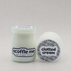 Two glass jars of Scoffle Me's homemade clotted cream placed so you can see the front and top view of the product packaging.