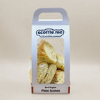 A cute white handled bag showcasing four delicious and rustic looking triangular scones.