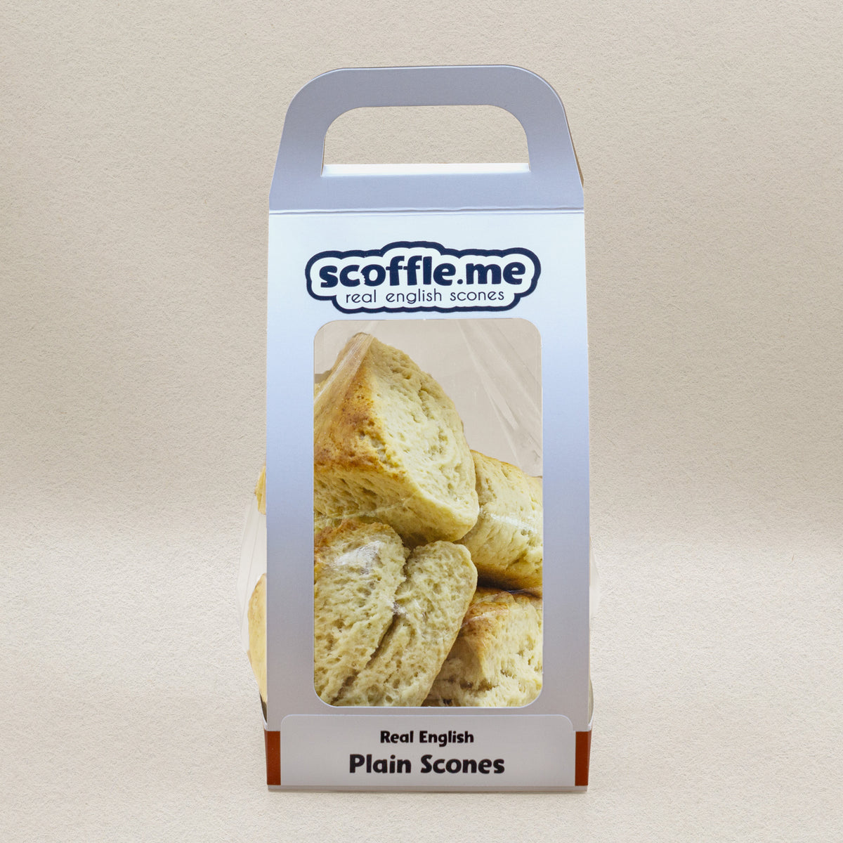 A cute white handled bag showcasing four delicious and rustic looking triangular scones.