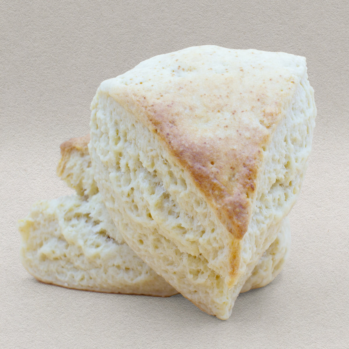 Two fluffy plain traditional English scones with a delightful golden crust.