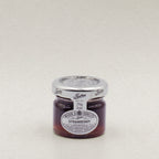 A 28g glass jar of Wilkin & Sons strawberry jam.