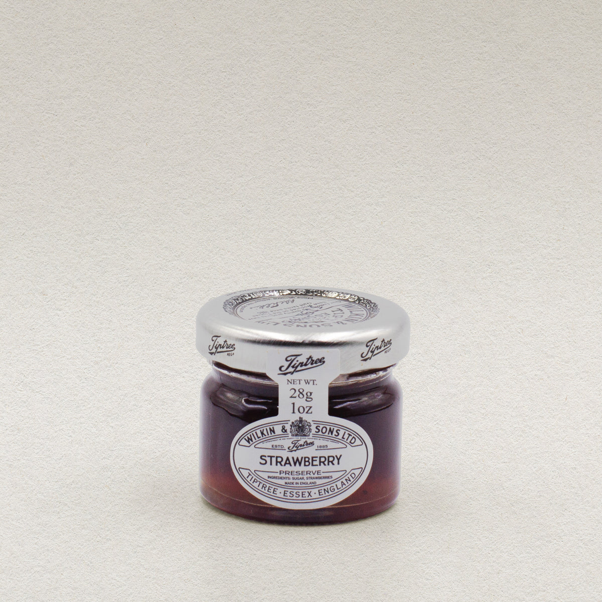 A 28g glass jar of Wilkin & Sons strawberry jam.